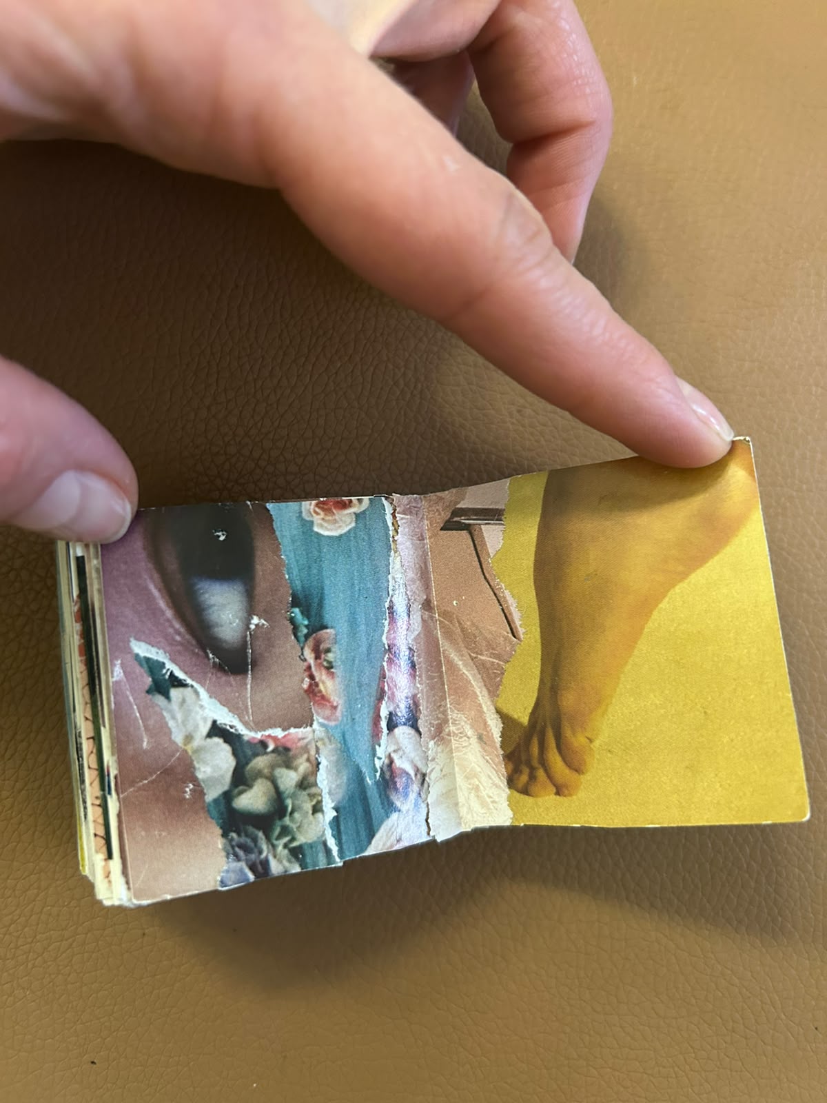 Handmade collage book opened to torn blue and golden-yellow paper